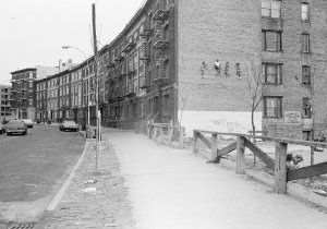 A sculpture of four girls jumping rope, installed on the side of a building
