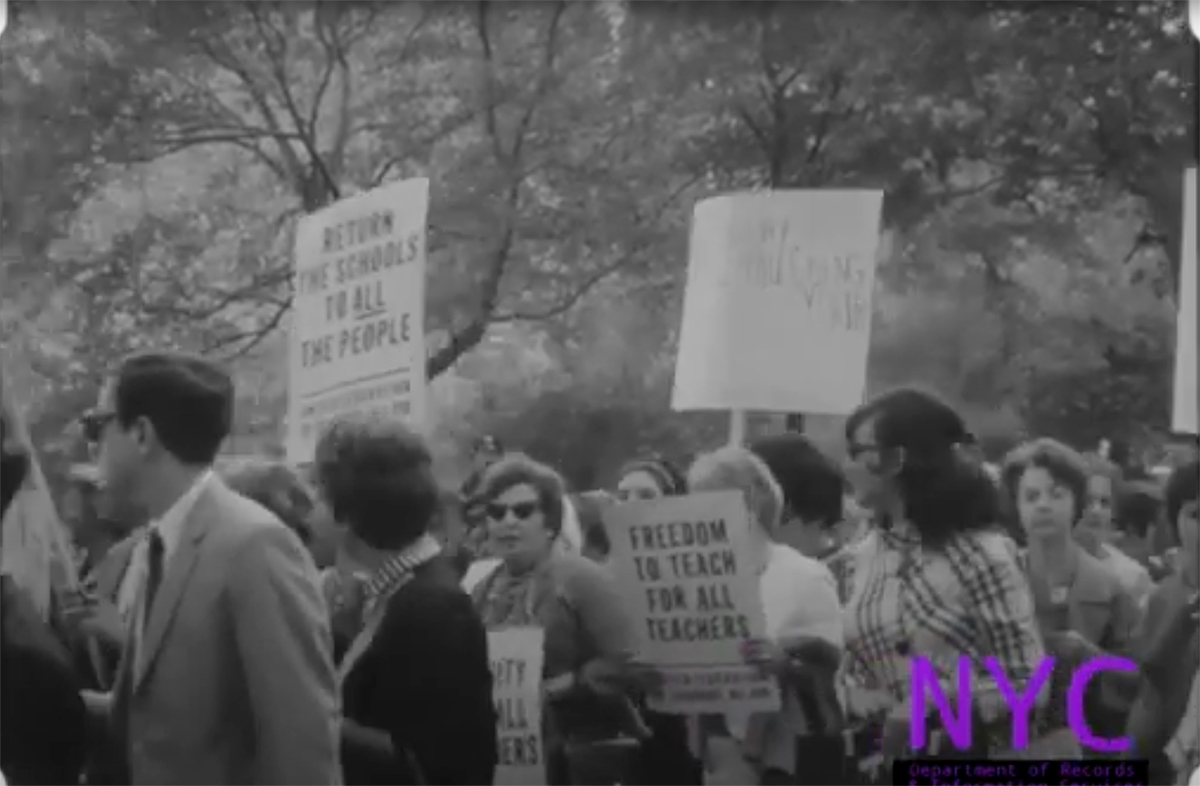 Teachers protesting and carrying signs near City Hall